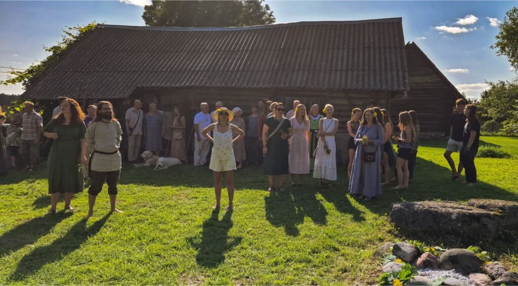 Pagonių bendruomenės susibūrimo dalyviai prie senos kaimo sodybos Lietuvoje